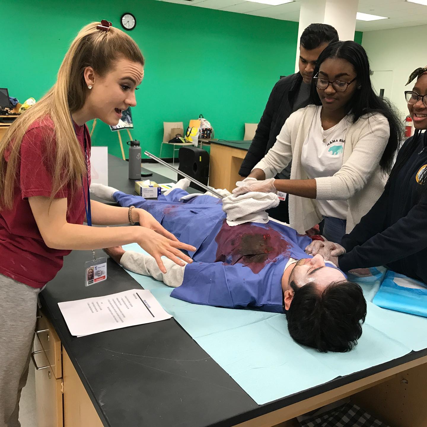 students practicing trauma medicine on another student with fake blood