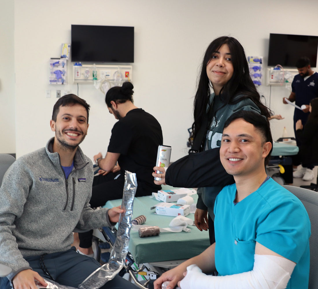 three students smiling while working together