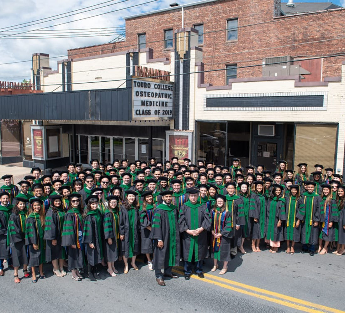 Class of 2019 graduates smiling outside commencement