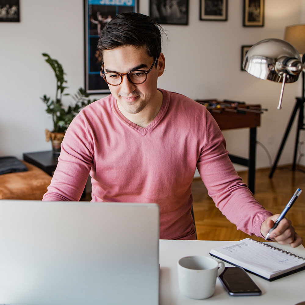Male student working on laptop from home