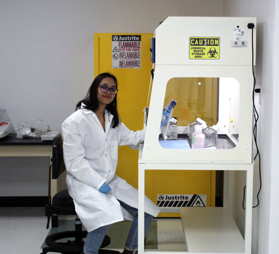 Student smiling while working in lab