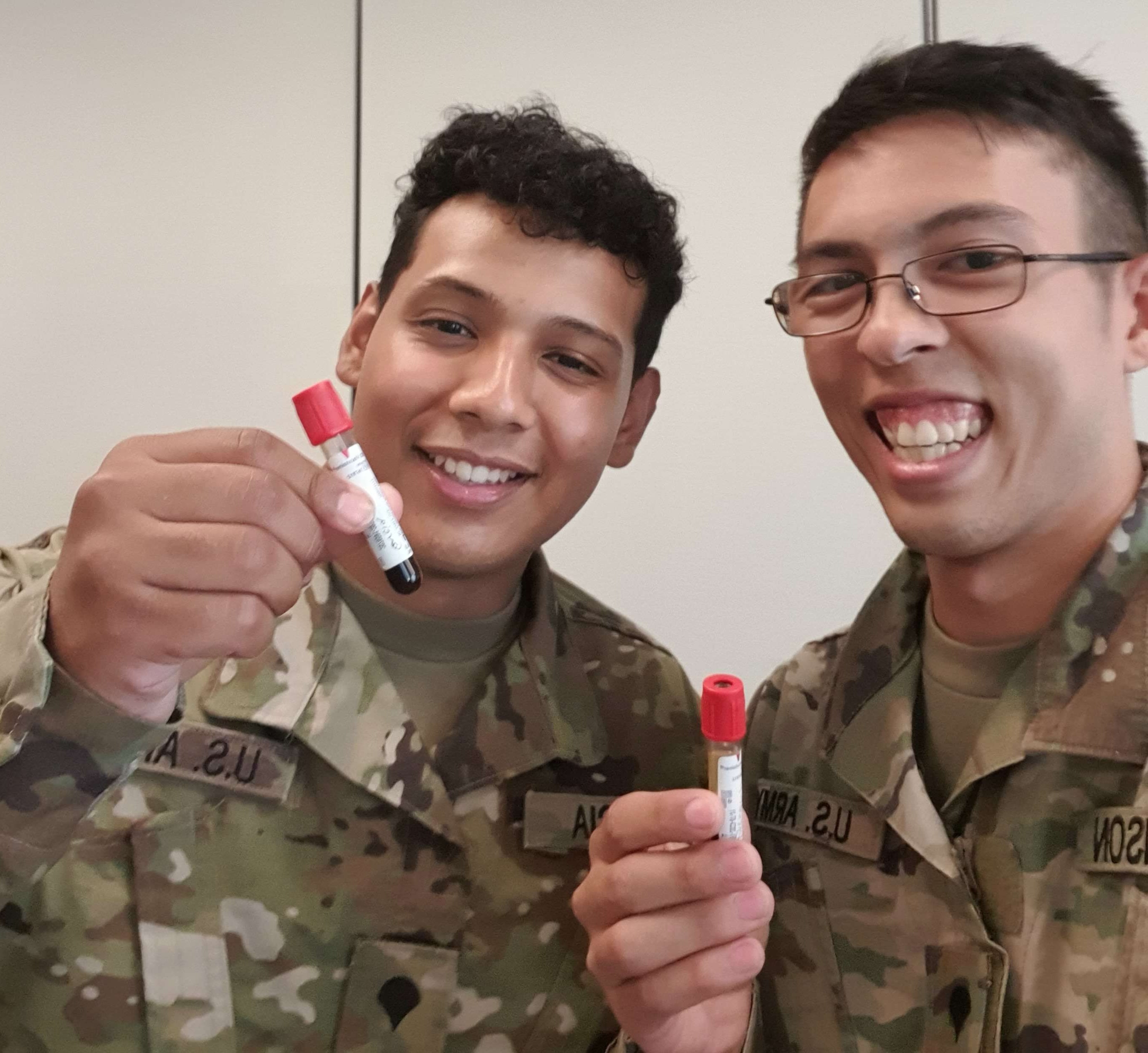 Joseph Garcia and Kenneth Swanson hold up vials of blood that they recently drew.
