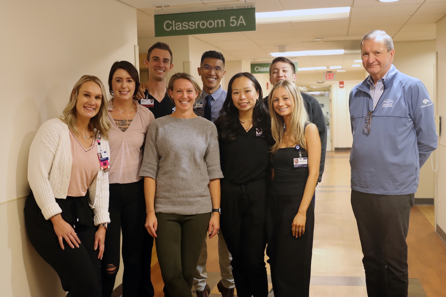 TouroCOM students stand next to a faculty member.