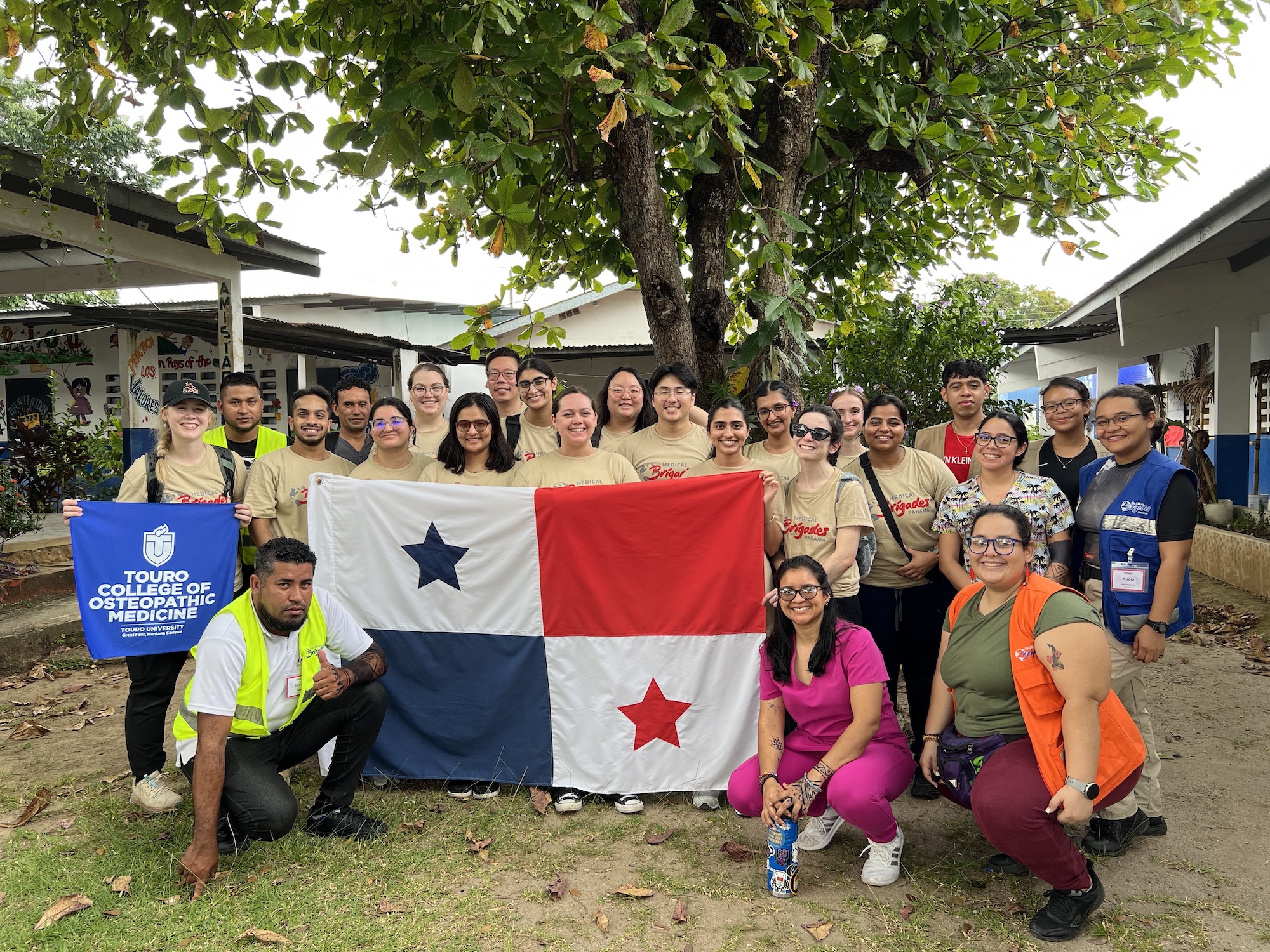 TouroCOM students and other volunteers hold up a Panama flag.