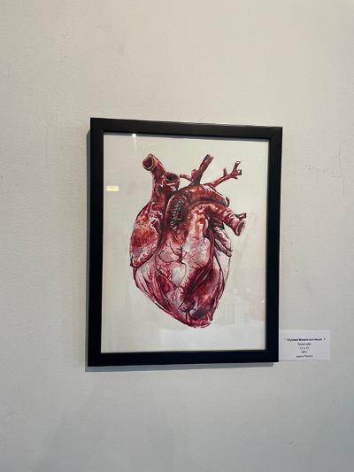 A stylized watercolor human heart painted on paper.