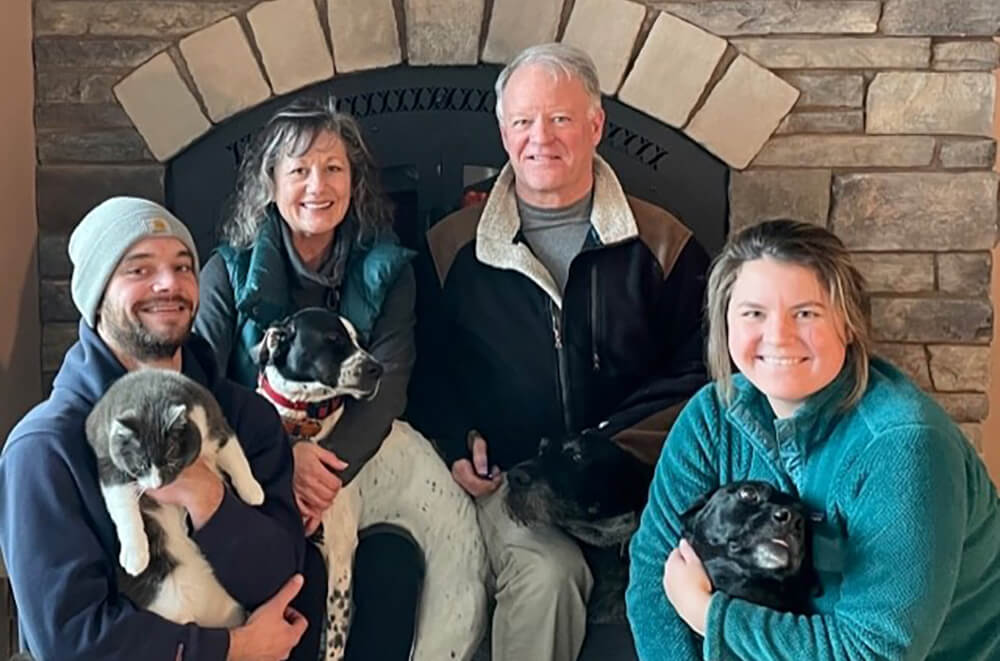 Dr Jim Yturri with his family sitting in front of a fireplace