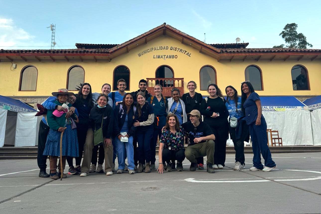 Group of medical students and their professors standing in a group outside a building in Peru. 